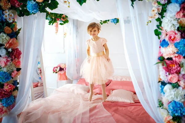 Niña alegre saltando en la cama — Foto de Stock