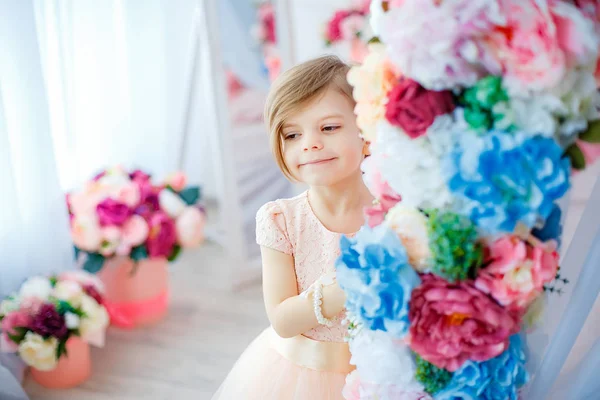 Lächelndes Mädchen zwischen Blumen — Stockfoto