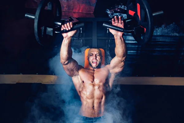 El deportista que hace ejercicios sobre los músculos pectorales en el humo. GYM — Foto de Stock