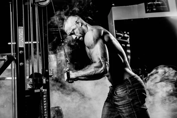 Handsome Muscular Fitness Bodybuilder laver tung vægt motion for triceps i gymnastiksalen - Stock-foto