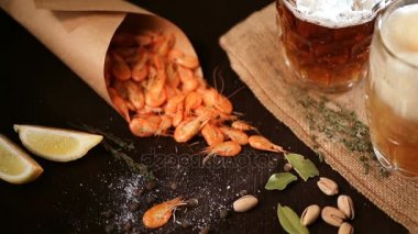 Bira bardağı ve ahşap masa üzerinde ızgara karides bardak doldurur