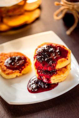 yeşil, papatya çayı ile beyaz tabakta tatlı peynir krep. Seçici odak. Sığ derinlik-in tarla.