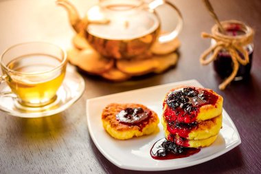 yeşil, papatya çayı ile beyaz tabakta tatlı peynir krep. Seçici odak. Sığ derinlik-in tarla.