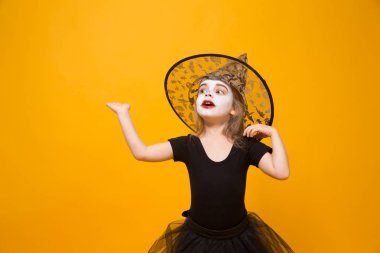 Halloween cadı kostüm, turuncu arka planda küçük kız.