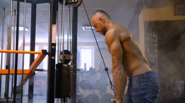 Kas Fitness vücut geliştirmeci Triceps jimnastik salonu için ağır egzersiz yapmak. Arka plan üzerinde duman
