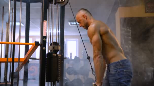 Muskulöser Fitness-Bodybuilder beim Krafttraining für Trizeps im Fitnessstudio. Rauch im Hintergrund — Stockvideo