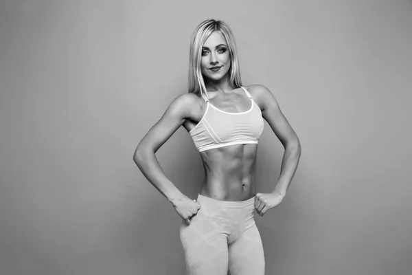 Blonde bodybuilder jong volwassen sexy meisje met lang haar. Portret van slanke sportieve. Zeer hete vrouw. Kopieer ruimte. Platte buik met pers. — Stockfoto