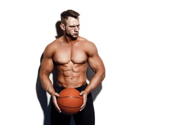 Bir basketbol studio tutan çok kaslı çıplak adam