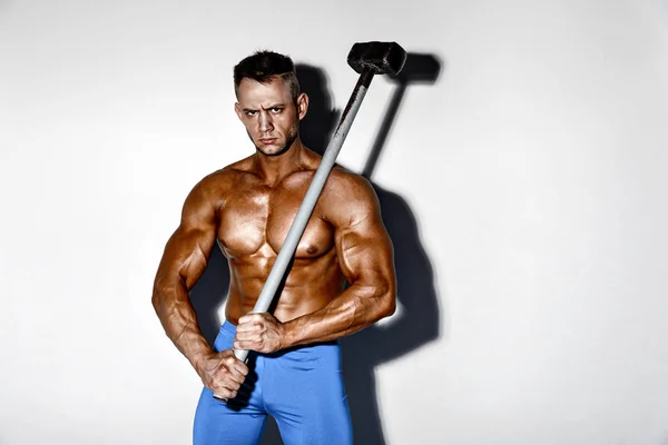 Idrottsman och hammare. kille med en fin muskel kondition, bodybuilder Håll stora metal hammer — Stockfoto