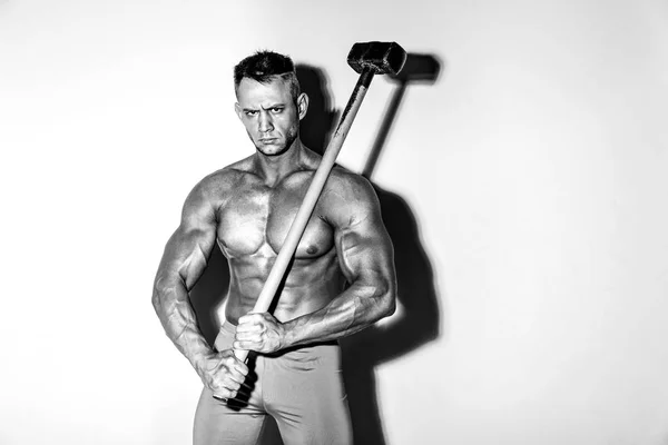 Athlète et marteau. gars avec une belle forme musculaire, bodybuilder tenir grand marteau en métal — Photo