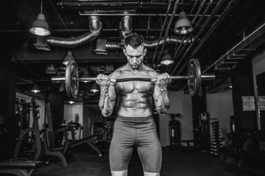 Pazı eğitim yaparken bir halter salonunda, çalışma genç yakışıklı beyaz vücut geliştirmeci sporcu.
