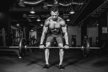 Spor salonunda Deadlift egzersiz yaparak gömleksiz delikanlı. motivasyon.