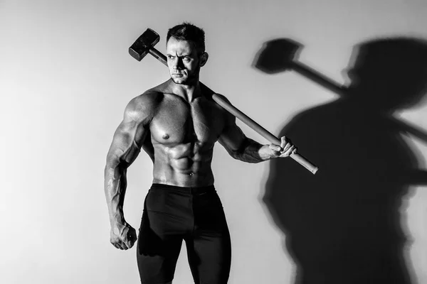 Athlète et marteau. gars avec une belle forme musculaire, bodybuilder tenir grand marteau en métal — Photo
