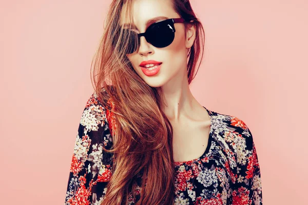 Ritratto di giovane bella donna magra in abito sexy con labbra sensuali in studio indossando occhiali da sole sorridente e in posa — Foto Stock