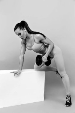 Kaslı kadın dumbell ile çalışma dışarı. İzole. Gri