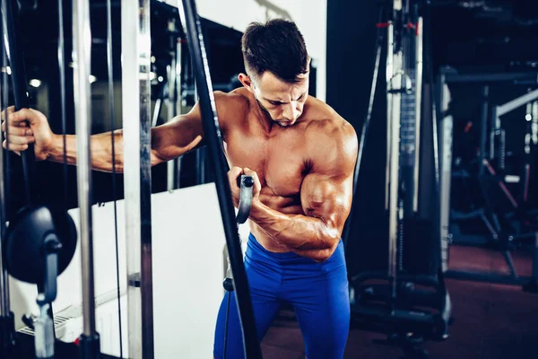 Jeune bodybuilder faisant l'exercice lourd de poids pour des biceps — Photo