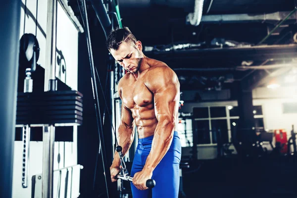 Jeune bodybuilder faisant l'exercice lourd de poids pour des triceps — Photo