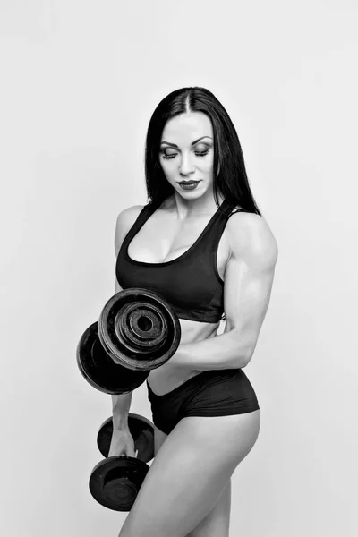 Muscular woman working out with dumbbells. Isolated. Gray — Stock Photo, Image