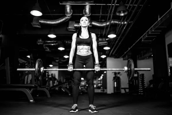 Muscular joven fitness mujer haciendo ejercicio de levantamiento de pesas pesado en el gimnasio — Foto de Stock