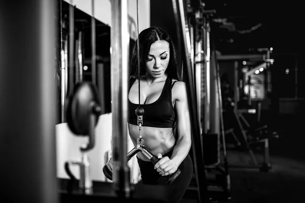 Mujer flexionando los músculos en la máquina de cable en el gimnasio. ejercicio en tríceps —  Fotos de Stock