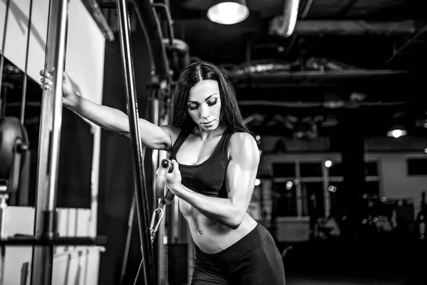 可弯曲的肌肉在健身房中电缆机上的女人。在二头肌锻炼 — 图库照片
