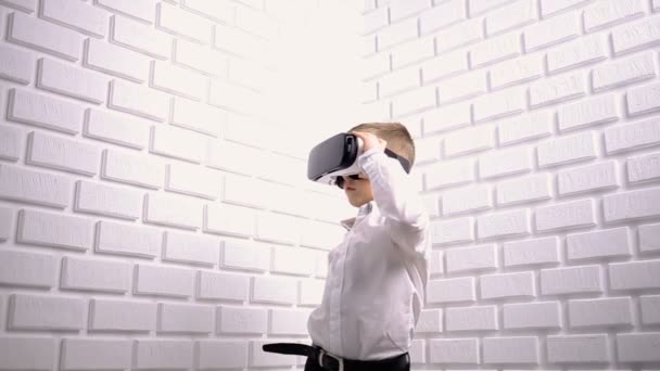 Menino usando dispositivo de realidade virtual em estúdio — Vídeo de Stock