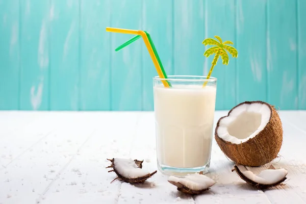 Vaso de leche de coco sobre mesa de madera blanca. Enfoque selectivo — Foto de Stock