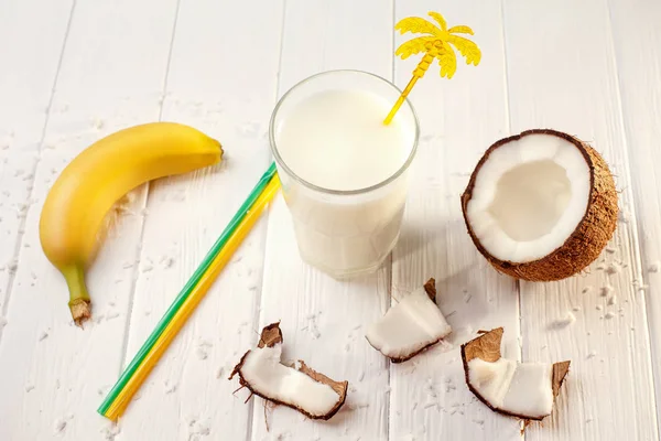 Copo de leite de coco na mesa de madeira branca, bananas. Tropical. Foco seletivo — Fotografia de Stock