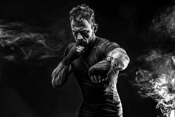 Un uomo muscoloso che fuma. Studio. — Foto Stock
