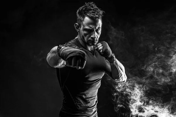 筋肉男は煙でパンチします。スタジオ — ストック写真