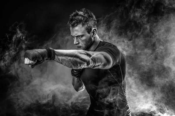 Hombre musculoso golpeando el humo. Estudio —  Fotos de Stock