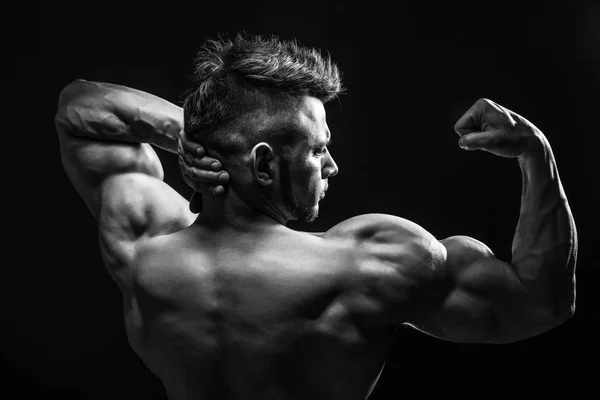 Strong Athletic Fitness Hombre posando músculos de la espalda, tríceps, latissimus sobre fondo negro — Foto de Stock