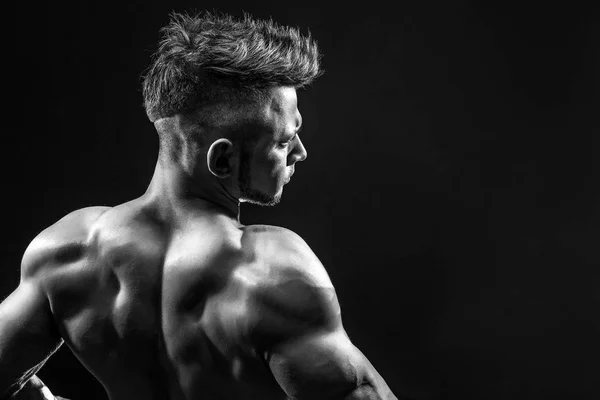 Strong Athletic Fitness Hombre posando músculos de la espalda, tríceps, latissimus sobre fondo negro — Foto de Stock