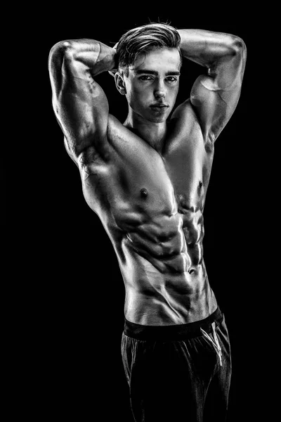 Bodybuilder fort avec six pack, abdos parfaits, épaules, biceps, triceps et poitrine, entraîneur de fitness personnel fléchissant ses muscles — Photo