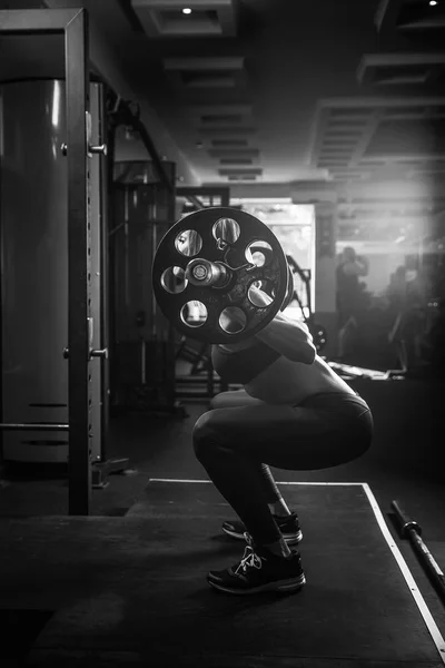 Joven chica sexy en el gimnasio haciendo sentadilla — Foto de Stock