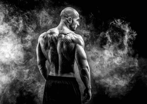 Back view of tattoed muscular man posing. Looking sideways — Stock Photo, Image