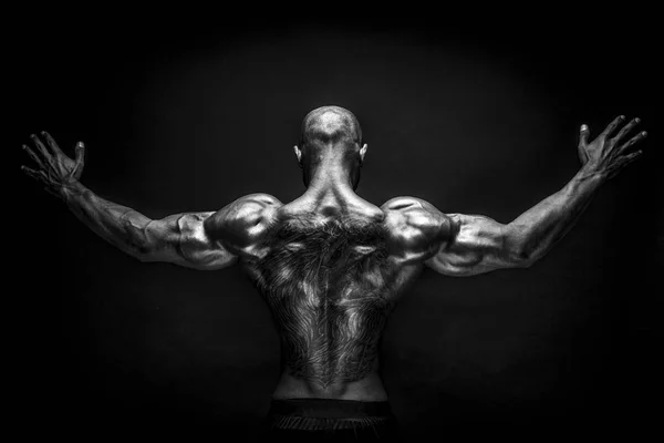 Back view of tattoed bodybuilder with outstretched arms — Stock Photo, Image