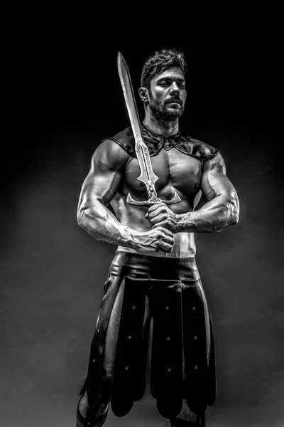 Svår barbar i läder kostym med svärd — Stockfoto