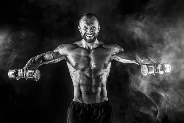 Erős sportoló nehéz súlyzót emel füstbe — Stock Fotó