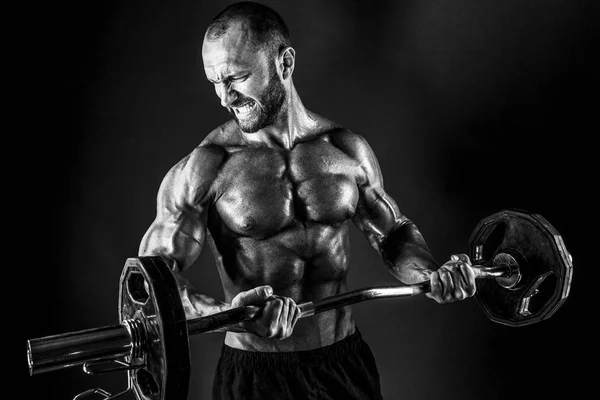 Hombre resistente haciendo ejercicio con barra pesada — Foto de Stock
