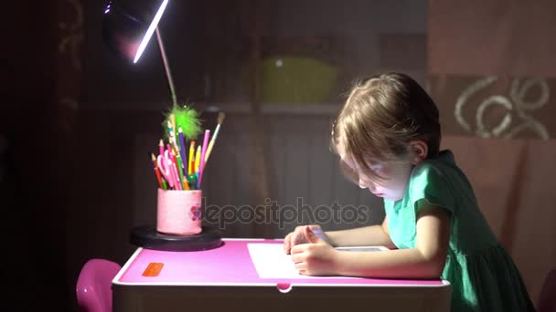Маленькая милая девочка сидит и смотрит планшет — стоковое видео