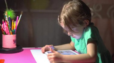 Oturma ve tablet izlerken küçük şirin kız