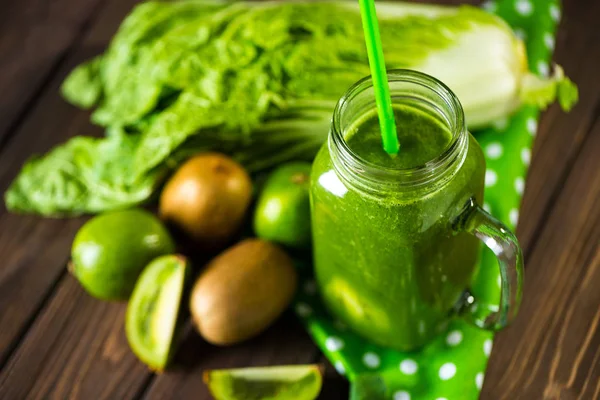 Misturado smoothie verde com ingredientes na mesa de madeira foco seletivo — Fotografia de Stock