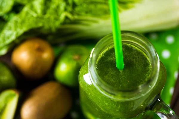 Blended green smoothie with ingredients on wooden table selective focus — Stock Photo, Image