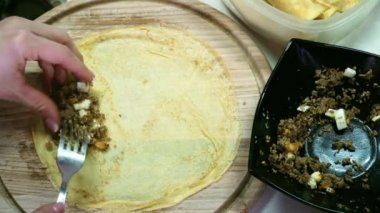 Şef kadınlar el ile et doldurma krep pişirme. Yakın çekim.