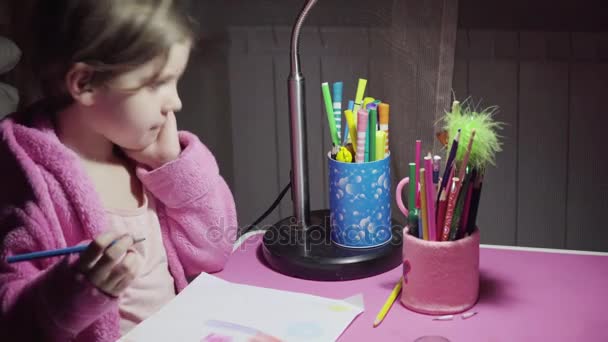 Pembe bornoz güzel küçük kız ile renkli kalemler resimde çekiyor. — Stok video