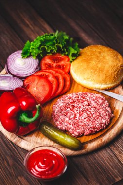 Ham zemin sığır eti Burger biftek pirzola baharat, peynir, domates, salata ve vintage ahşap kurullarında topuz