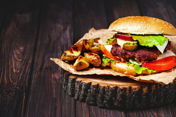 Zbliżenie wołowiny domowe hamburgery z sałatą i majonez serwowane na małą drewnianą deską do krojenia. Ciemne tło — Zdjęcie stockowe