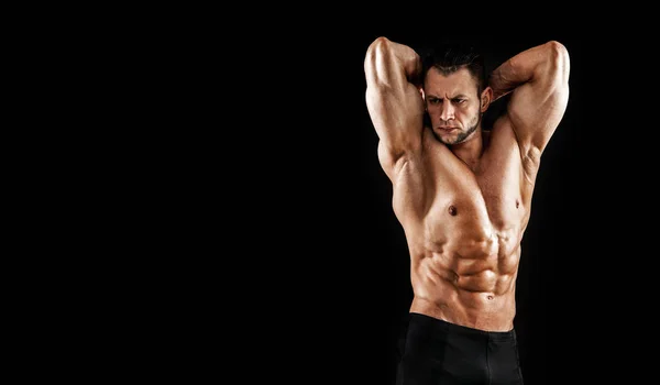 Handsome male model posing at studio in front of a black background. — Stock Photo, Image