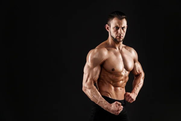 Bonito modelo masculino posando no estúdio na frente de um fundo preto. — Fotografia de Stock